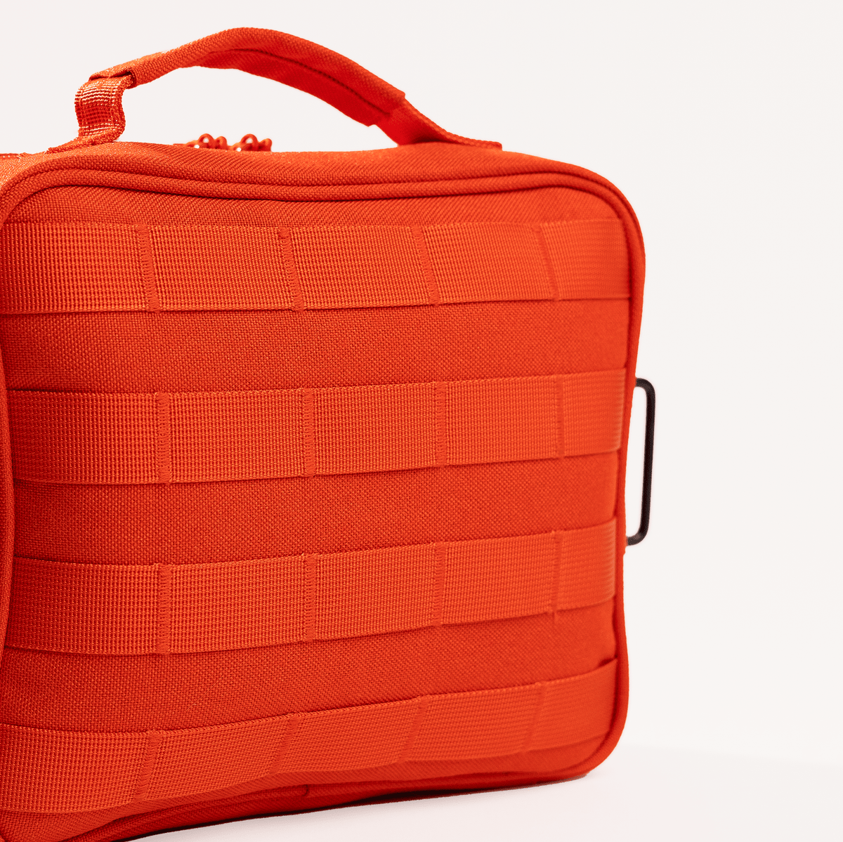 Back of The Roadie readiness kit showing durable orange 1000D Cordura nylon, MOLLE-style webbing and carry handle