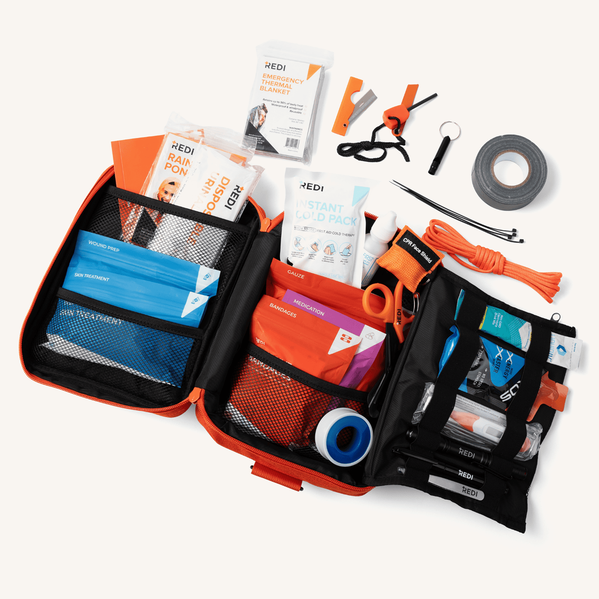 The Roadie car first aid kit opened flat with color-coded pouches, duct tape, paracord, trauma shears and tools
