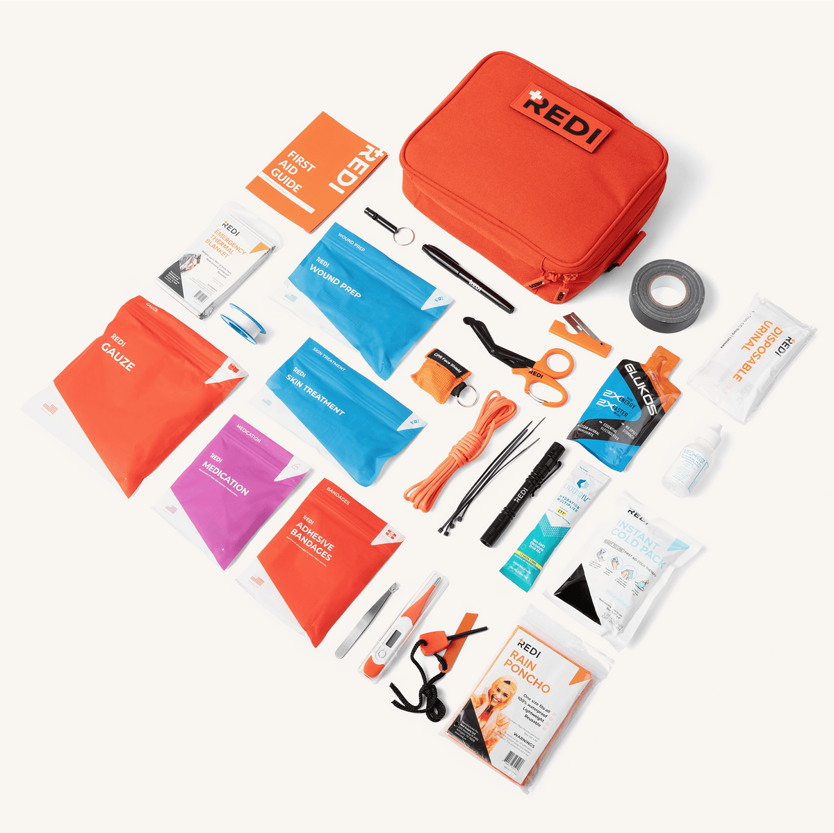 Flat lay of all 115 items in The Roadie car emergency kit: color-coded first aid pouches, tools, duct tape and paracord